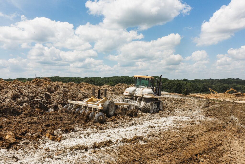 Tractor pulling a disc across graded ground for the Vandalia Solar Farm in Vandalia, Missouri